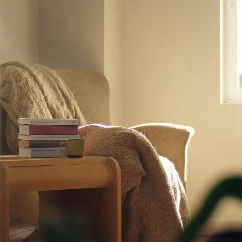 A cozy reading corner with a chunky knit throw