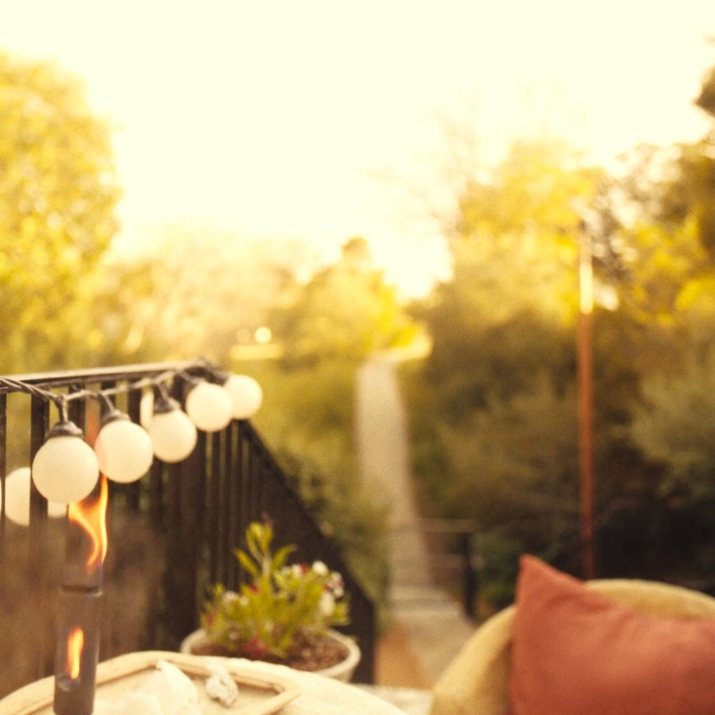 A sunlit porch with warm string lights