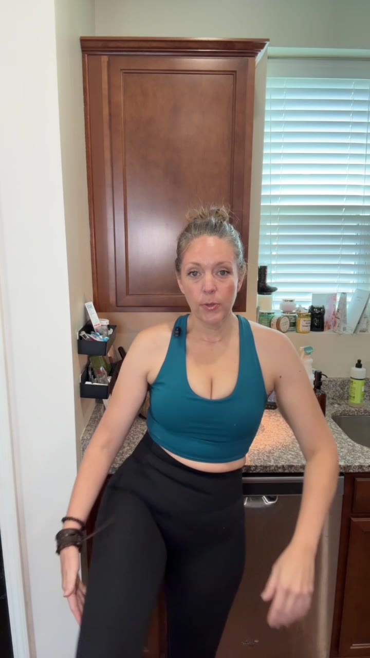Full body activewear try-on in a kitchen, teal top and black leggings.