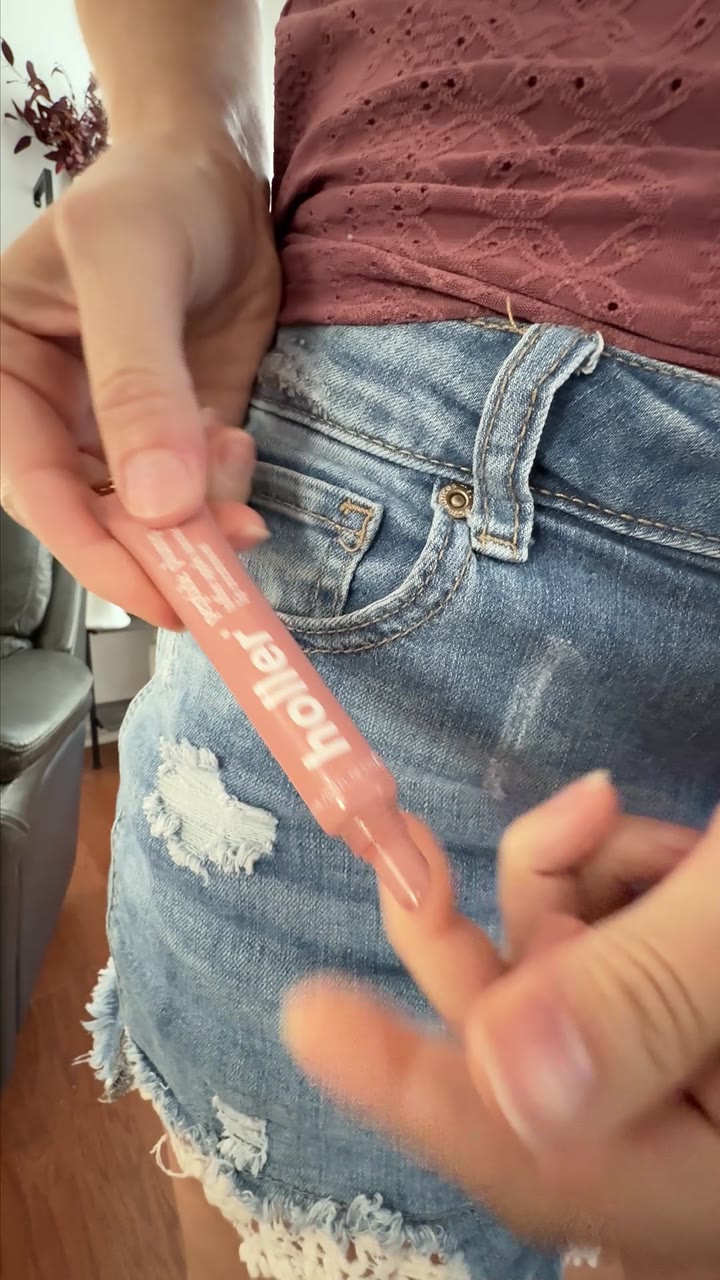 The Holler lip treatment keychain clipped to the belt loop of denim shorts.