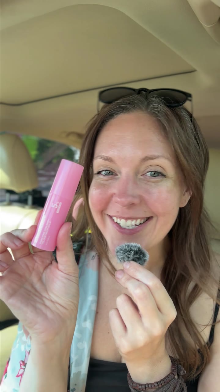 Holding the Medicube pore stick up to camera in the front seat of a car.