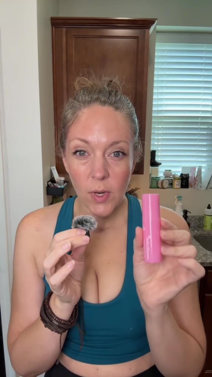Holding the Medicube pore stick and applicator up to camera in a kitchen.